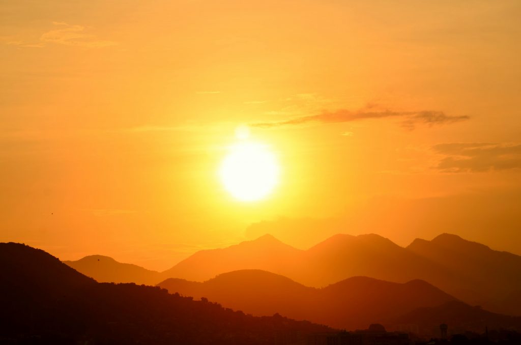 Stunning sunset over Rio de Janeiro's mountains, capturing the vibrant golden hues and silhouettes.