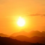 Stunning sunset over Rio de Janeiro's mountains, capturing the vibrant golden hues and silhouettes.